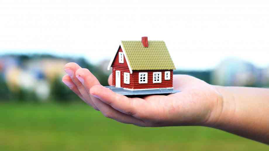 Hand holding a model house. Hand holding a model house.