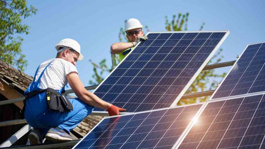 Construction workers installing solar panels Construction workers installing solar panels