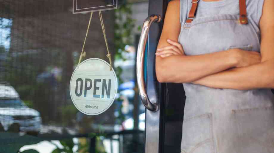 Business owner outside a small café.