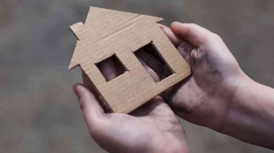 Child holding cardboard house Child holding cardboard house